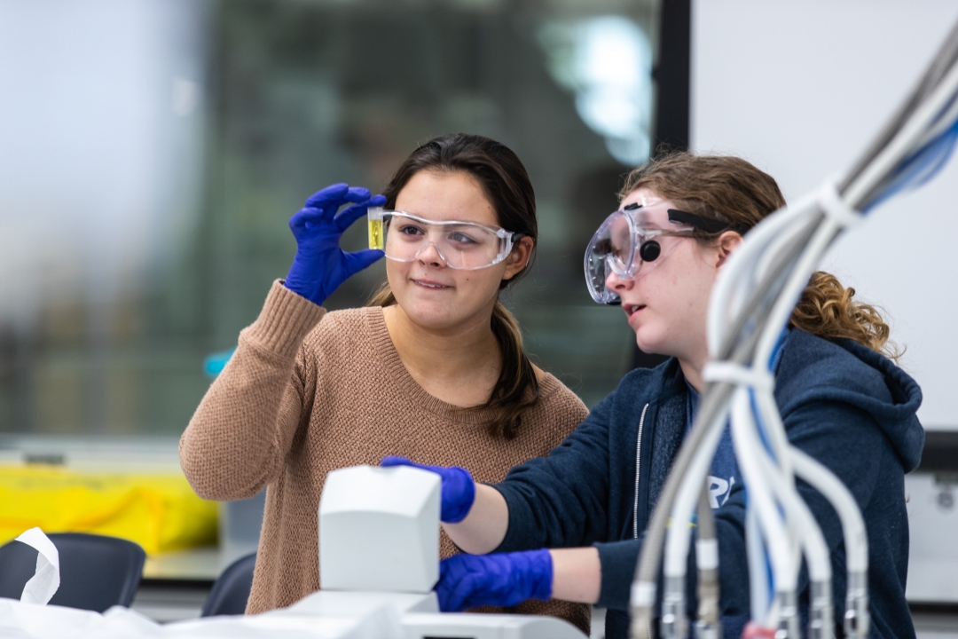 Two GW students working with a test tube
