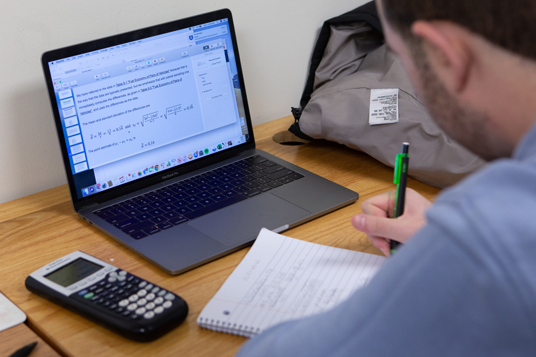 A student writing on a notepad