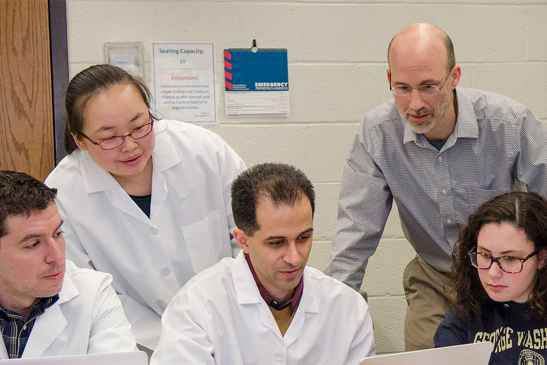 A group of GW health students and professor in a classroom