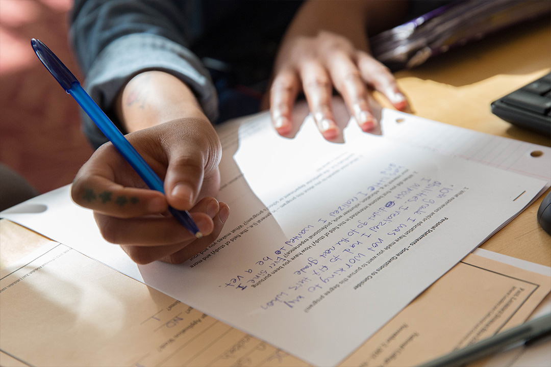 detail shot of the hand of a person writing on a piece of paper